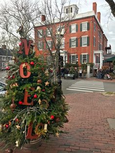 a decorated christmas tree in front of a brick building