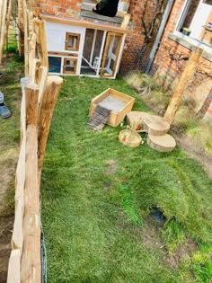 an outdoor area with grass, wooden furniture and a dog house in the back ground