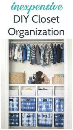 an organized closet with blue and white boxes, baskets and clothes hanging on the wall