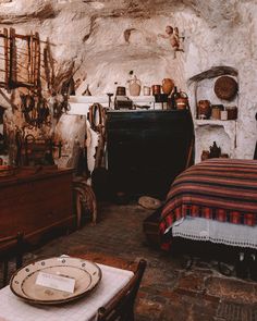 an old fashioned bedroom with stone walls and flooring, including a bed in the corner