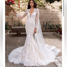 a woman in a white wedding dress is posing for the camera