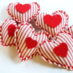 red and white striped heart shaped hair clips with hearts on them sitting on a table