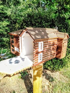 a small wooden house sitting on top of a wooden post