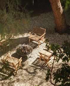 an outdoor fire pit surrounded by wooden chairs