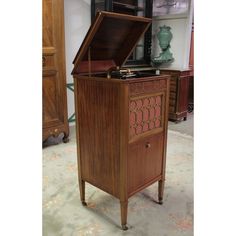 an old fashioned record player sitting on top of a wooden cabinet