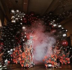 a group of balloons and flowers in front of a stage set up for a halloween party