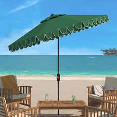 an umbrella on the beach with chairs and tables