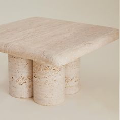 a table made out of concrete sitting on top of a white floor