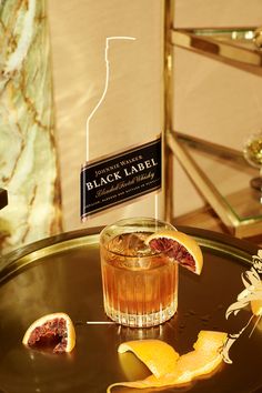 a black label cocktail on a tray with orange peels