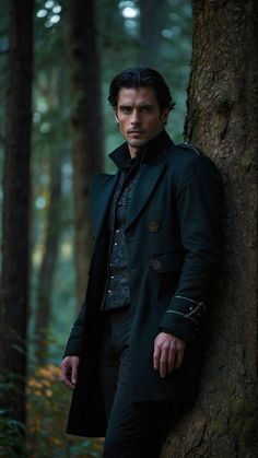 a man leaning against a tree in the woods wearing a black coat and dark pants