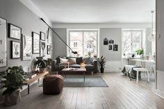 a living room filled with lots of furniture and pictures on the wall next to a fire place