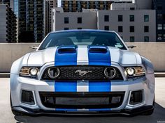 the front end of a silver and blue mustang