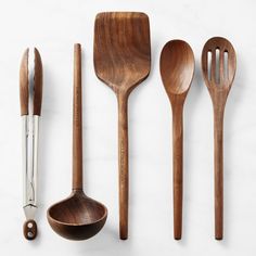 wooden utensils and spoons lined up on a white surface