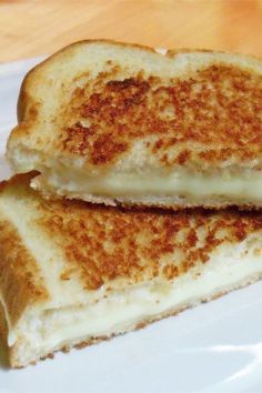 two grilled cheese sandwiches on a white plate