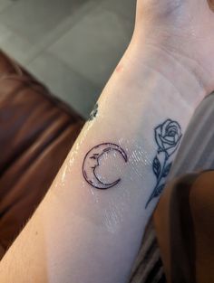 a person's arm with a tattoo on it that has a crescent and rose