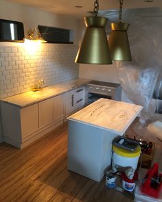 an unfinished kitchen with white cabinets and wood flooring