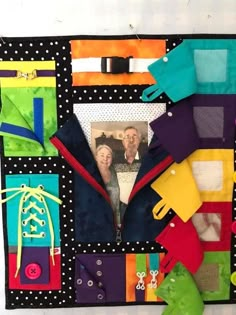 a quilted wall hanging with different colored pieces of clothing and a photo on it