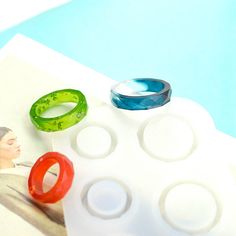 three different colored rings sitting on top of a piece of paper