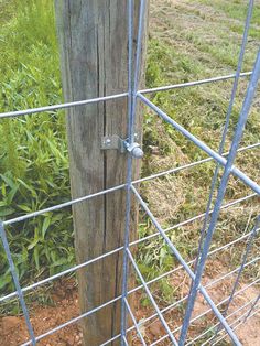 an old wooden post is attached to a wire fence