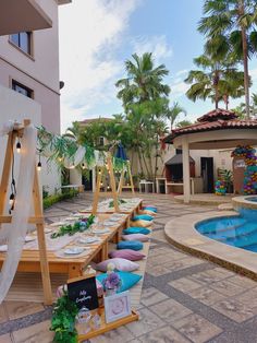 a long table is set up in front of a swimming pool for an outdoor party