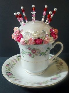 a teacup with flowers and pearls in it