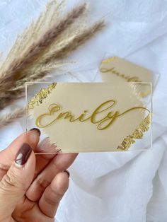 someone holding up a business card with the word'enlig'in gold foil