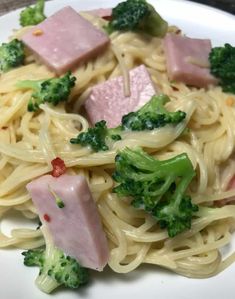 pasta with ham and broccoli on a white plate