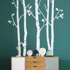 the wall decals in this room are white birch trees with green leaves on them