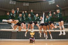 the volleyball team is jumping in the air