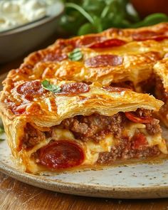 a close up of a slice of pizza on a plate with other food items in the background