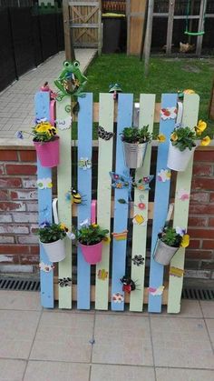 a wooden fence with potted plants attached to it