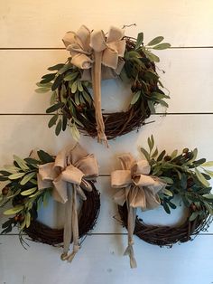 three wreaths with bows hanging on the wall