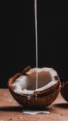 coconuts with milk being poured into them