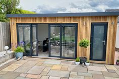 a small garden room with sliding glass doors and potted plants on the outside patio