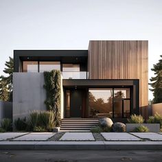 a modern house with an entry way leading to the front door and covered in plants