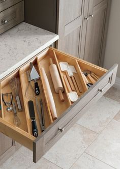 an open drawer in the middle of a kitchen