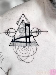 a man's chest with an abstract tattoo design on the upper part of his chest