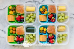 four plastic trays filled with different types of fruit and cheese on top of each other