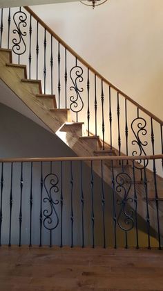 a stair case with wrought iron railing and wood handrails