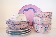 the dishes are stacked on top of each other in pink and blue speckles