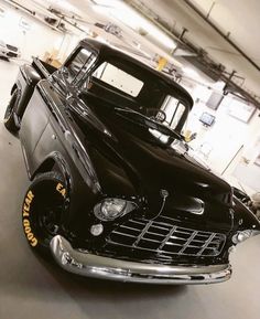 an old black truck parked in a garage