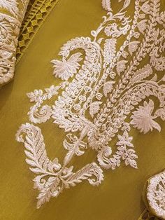 the fabric is gold and has white lace on it