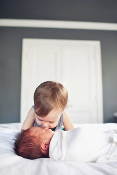 a baby is laying on top of an adult's head while they are kissing each other