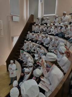 many people in white uniforms are sitting down