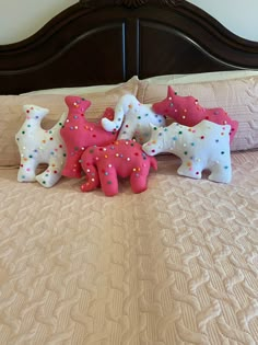 some pink and white decorated elephants on a bed