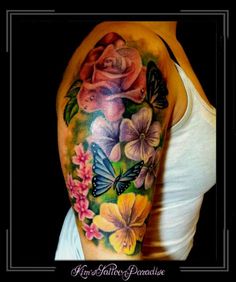 a woman's shoulder with flowers and butterflies on it