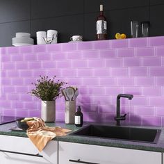 a kitchen with purple tiles on the wall