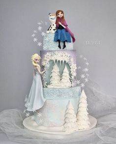 a three tiered cake decorated with frozen princess figures