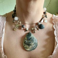 This unique necklace embodies the ideas of reusing materials and creative approach to design. The main accent is the sea shell pendant, which is harmoniously combined with pearls, crystal beads, mother-of-pearl pendants and metal cowries. All the elements of the necklace are connected by stainless steel fittings, which ensures the durability and reliability of the product. This necklace is ideal for creative and stylish people who like to stand out from the crowd. It will be a great addition to Sea Themed Necklace, Unique Mother Of Pearl Shell Pendant Necklace, Unique Shell Pendant Necklace, Unique Shell Necklaces, Unique Shell-shaped Necklace With Natural Stones, Unique Shell-shaped Shell Necklaces, Artisan Shell-shaped Necklace Made Of Shell, Sea Necklace, Stainless Steel Fittings