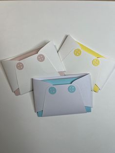 four envelopes with buttons on them sitting next to each other